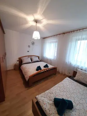 a bedroom with two beds and a chandelier at Holiday House Dori in Kobarid