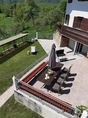 an overhead view of a patio with an umbrella and benches at Holiday House Dori in Kobarid