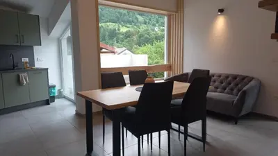 a dining room with a table and chairs and a couch at Hiša za Gradom in Kobarid