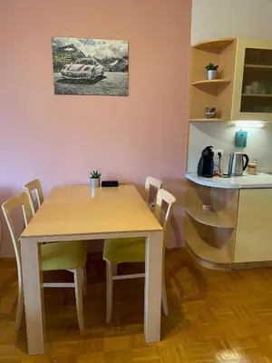 a table and chairs in a kitchen with a car on the wall at Apartma Felicija in Ljubljana