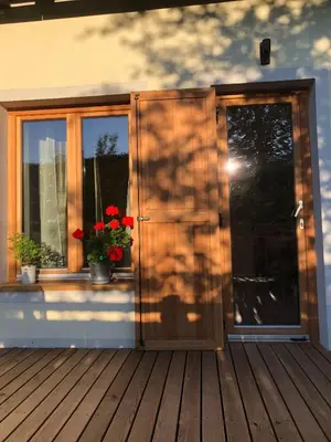 an open door to a deck with flowers on it at Quiet apartment with a terrace on Organic farm in Prevalje