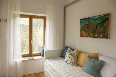 a living room with a couch and a window at Quiet apartment with a terrace on Organic farm in Prevalje