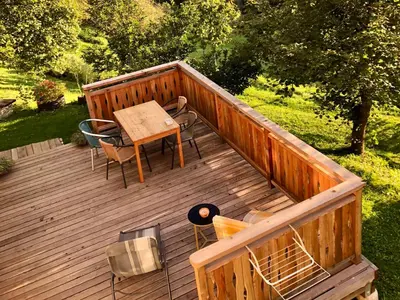 an overhead view of a wooden deck with a table and chairs at Quiet apartment with a terrace on Organic farm in Prevalje