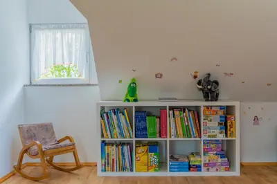 a book shelf filled with books next to a chair at Holiday Home Lanita with Two Bedrooms & Terrace in Podbočje