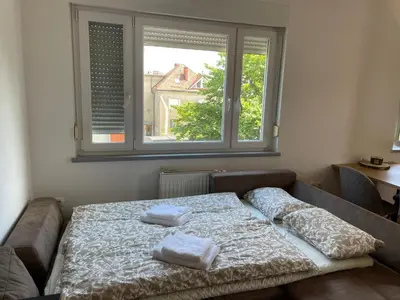 a bed in a room with two pillows on it at Mely Rose in Ljubljana