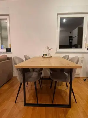 a wooden table and chairs in a living room at Mely Rose in Ljubljana