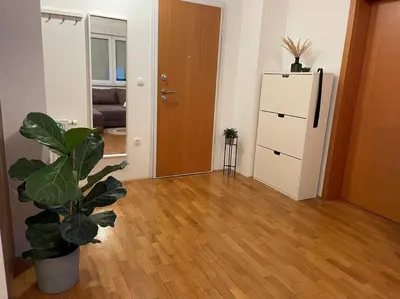 a living room with a plant and a refrigerator at Mely Rose in Ljubljana
