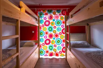a room with two bunk beds and a colorful wall at Hostel Soča Rocks in Bovec