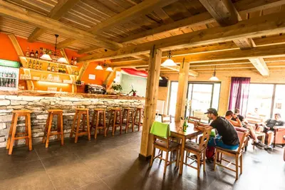 a group of people sitting at a table in a restaurant at Hostel Soča Rocks in Bovec
