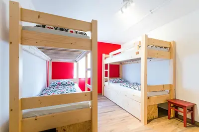 two bunk beds in a room with red walls at Hostel Soča Rocks in Bovec