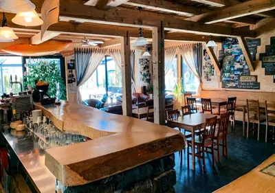 a bar in a restaurant with tables and chairs at Hostel Soča Rocks in Bovec