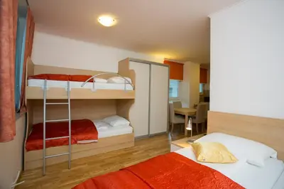 a bedroom with two bunk beds and a table at Apartments Benedičič in Bled