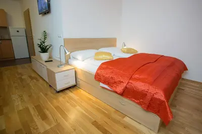 a bedroom with a bed with a red blanket on it at Apartments Benedičič in Bled