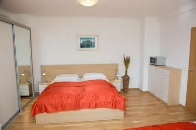 a bedroom with a large bed with a red blanket at Apartments Benedičič in Bled
