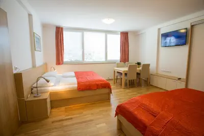 a hotel room with two beds and a table and chairs at Apartments Benedičič in Bled