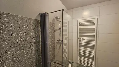 a shower with a glass door in a bathroom at Apartma Sava-Stol in Jesenice