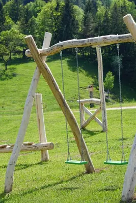 an empty swing set in a grassy field at Cowboy's Land in Višnja Gora