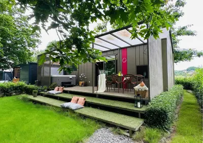 a tiny house with a garden and a patio at MAGNOLIA HOUSE by the RIVER XL in Metlika