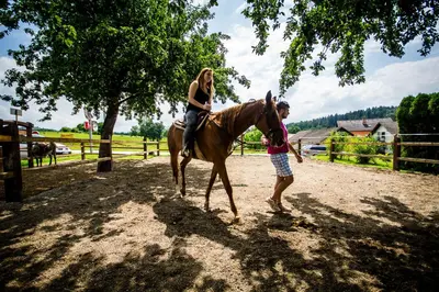 a woman riding a horse next to a man at MAGNOLIA HOUSE by the RIVER XL in Metlika