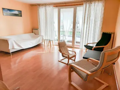 a room with a bed and two chairs and a bed and windows at Apartment Otava in Šempas