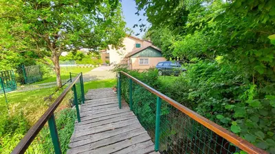 a wooden walkway leading to a house with a car at Apartment Otava in Šempas
