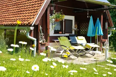 a patio with chairs and umbrellas on a house at Emerald Bell Cottage - Smaragdni Zvonček in Gomilsko