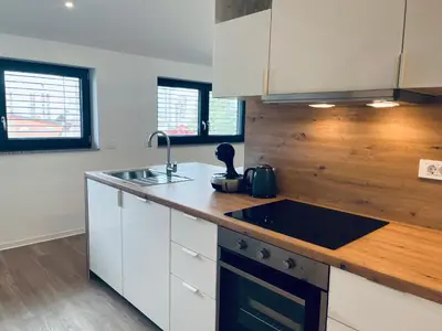 a kitchen with white cabinets and a black sink at Villa Kovačeva 15, app 2, free parking in Ljubljana