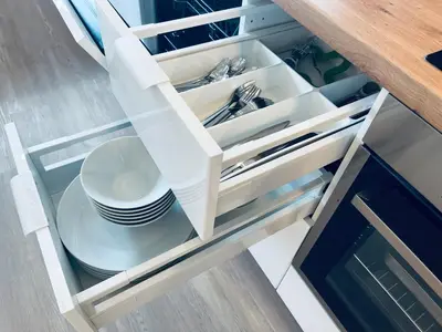 an open cabinet with plates and utensils in it at Villa Kovačeva 15, app 2, free parking in Ljubljana