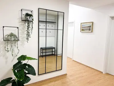 a mirror in a white room with a plant at Apartment VIČ in Ljubljana