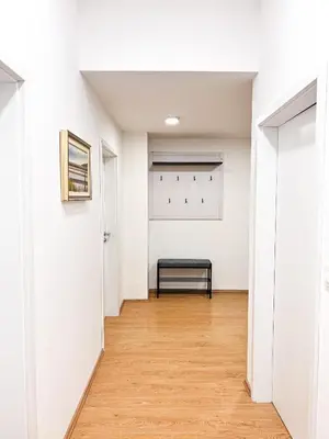 an empty hallway with a bench in a white room at Apartment VIČ in Ljubljana