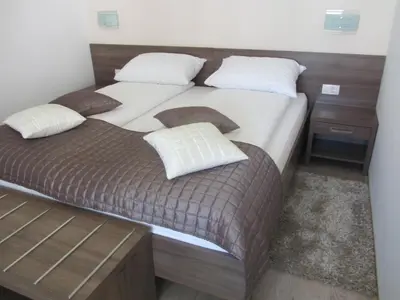a bedroom with two beds with white sheets and pillows at Villa Tollazzi in Logatec