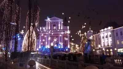 a city lit up with christmas lights and a clock tower at Villa Tollazzi in Logatec