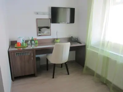 a desk with a white chair and a mirror at Villa Tollazzi in Logatec
