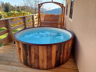 a large wooden hot tub on a deck at Sunflower House with Jacuzzy and Sauna in Vitanje