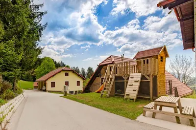 a playground with a slide and a house at Sunflower House with Jacuzzy and Sauna in Vitanje