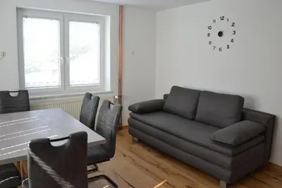 a living room with a couch and a table at Apartma ob potoku in Luče