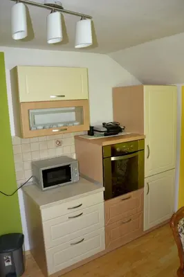 a small kitchen with a microwave and a stove at Apartma ob potoku in Luče
