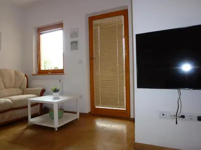 a living room with a tv and a couch and a table at Apartment Jalps 2 in Bohinj