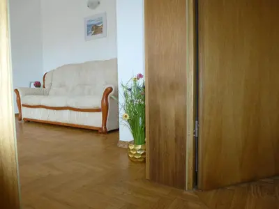 a living room with a door and a couch at Apartment Jalps 2 in Bohinj