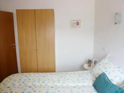 a bedroom with a bed and a wooden cabinet at Apartment Jalps 2 in Bohinj