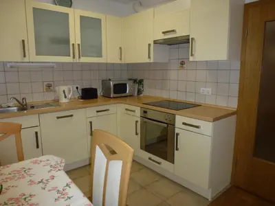 a kitchen with white cabinets and a stove top oven at Apartment Jalps 2 in Bohinj