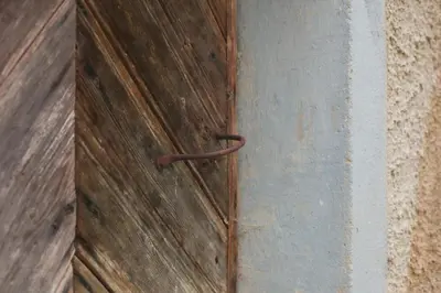 a wooden door with a metal handle on a wall at Apartma Gorski razgled in Srednja Vas v Bohinju