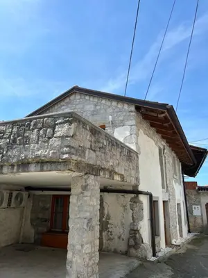 an old stone building with a red door at Guesthouse 45 in Dutovlje