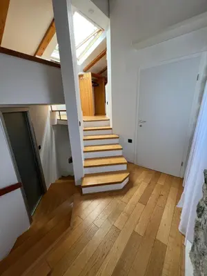 a staircase in a room with white walls and wooden floors at Guesthouse 45 in Dutovlje