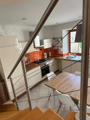 a kitchen with a wooden table and a dining room at Guesthouse 45 in Dutovlje