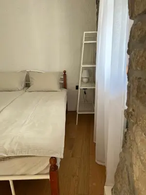 a small bedroom with a bed and a ladder at Guesthouse 45 in Dutovlje