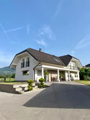 a large white house with a driveway at Hiša Helena in Kranj
