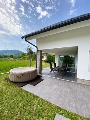 a patio with a table and a large ottoman at Hiša Helena in Kranj