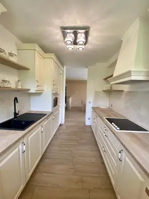 a kitchen with white cabinets and a sink at Hiša Helena in Kranj