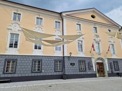 a large yellow and white building on a street at Studio Lotrist in Radovljica